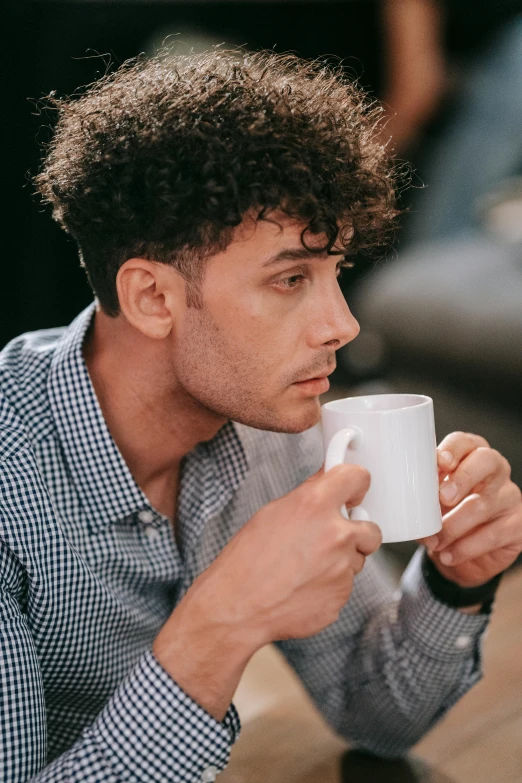 man in plaid shirt holding up a coffee mug