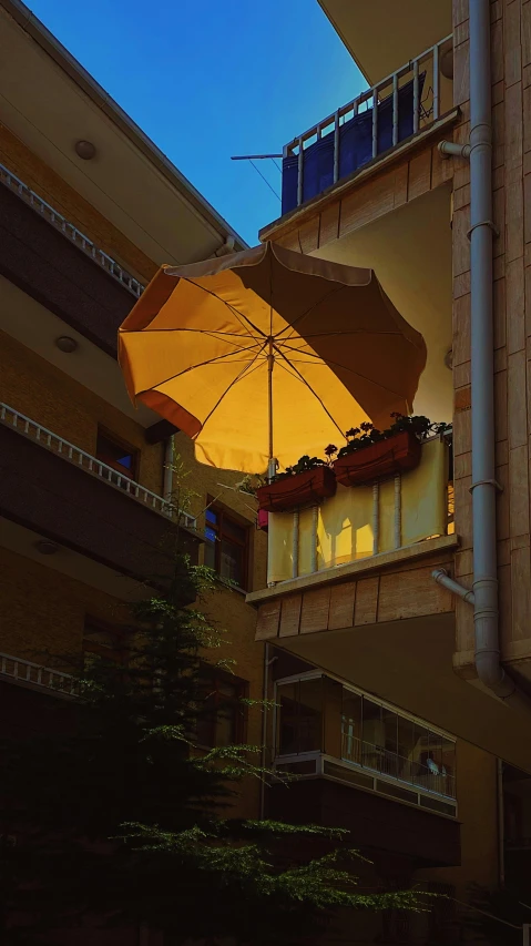 an umbrella sits on top of a balcony overlooking a tree