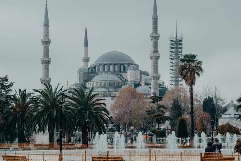 a beautiful grey mosque that sits above the surrounding park