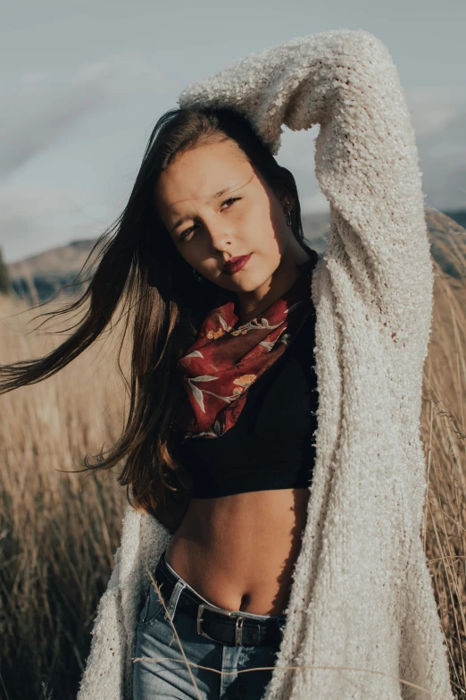 the girl poses in a field of tall grass