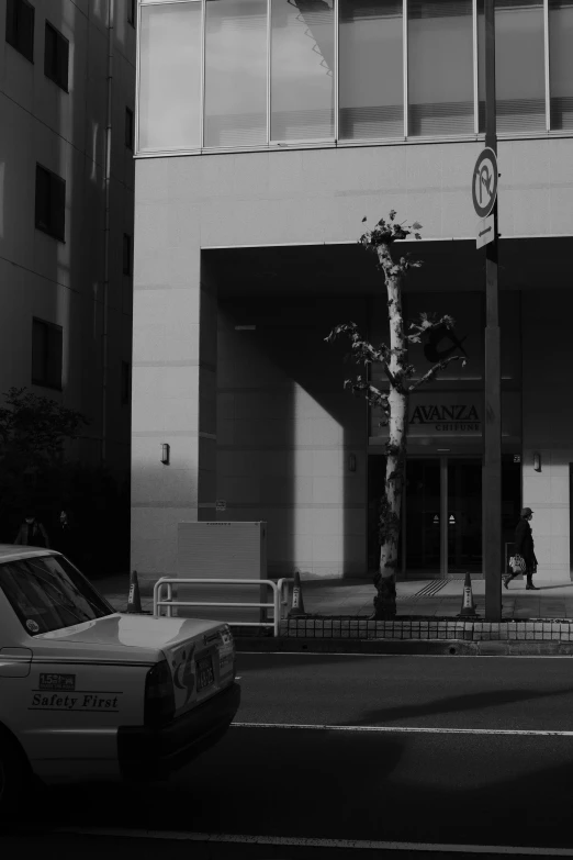 the taxi is parked in front of the tall building