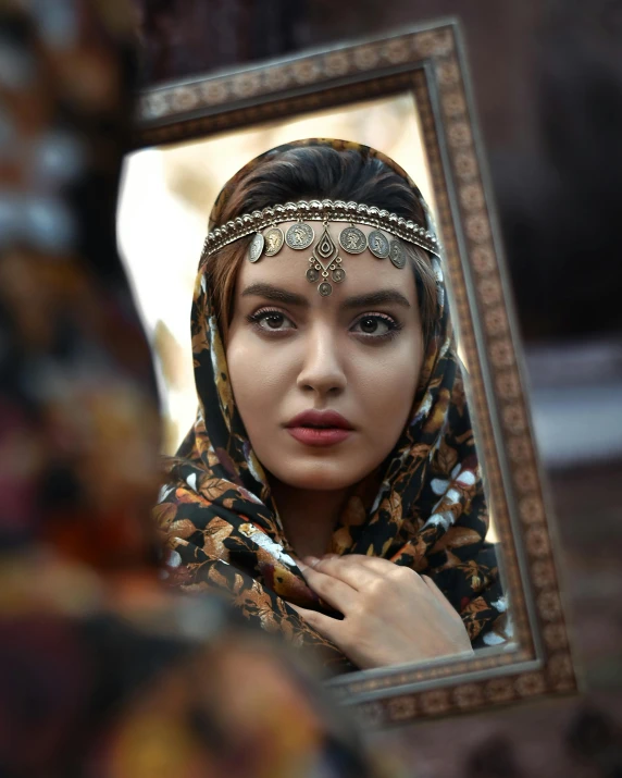 a woman is looking into the mirror wearing a headdress