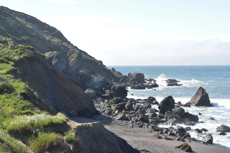 a couple of rocky beach with water in the distance