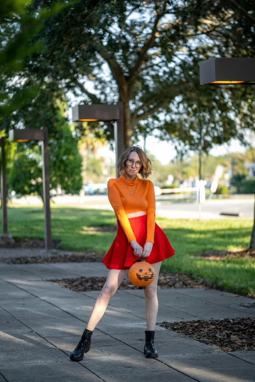 a woman is posing in a short skirt holding a basketball