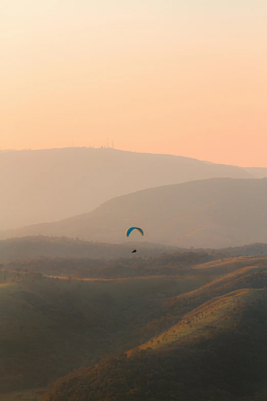 two parachutes flying in the sky over a grassy field