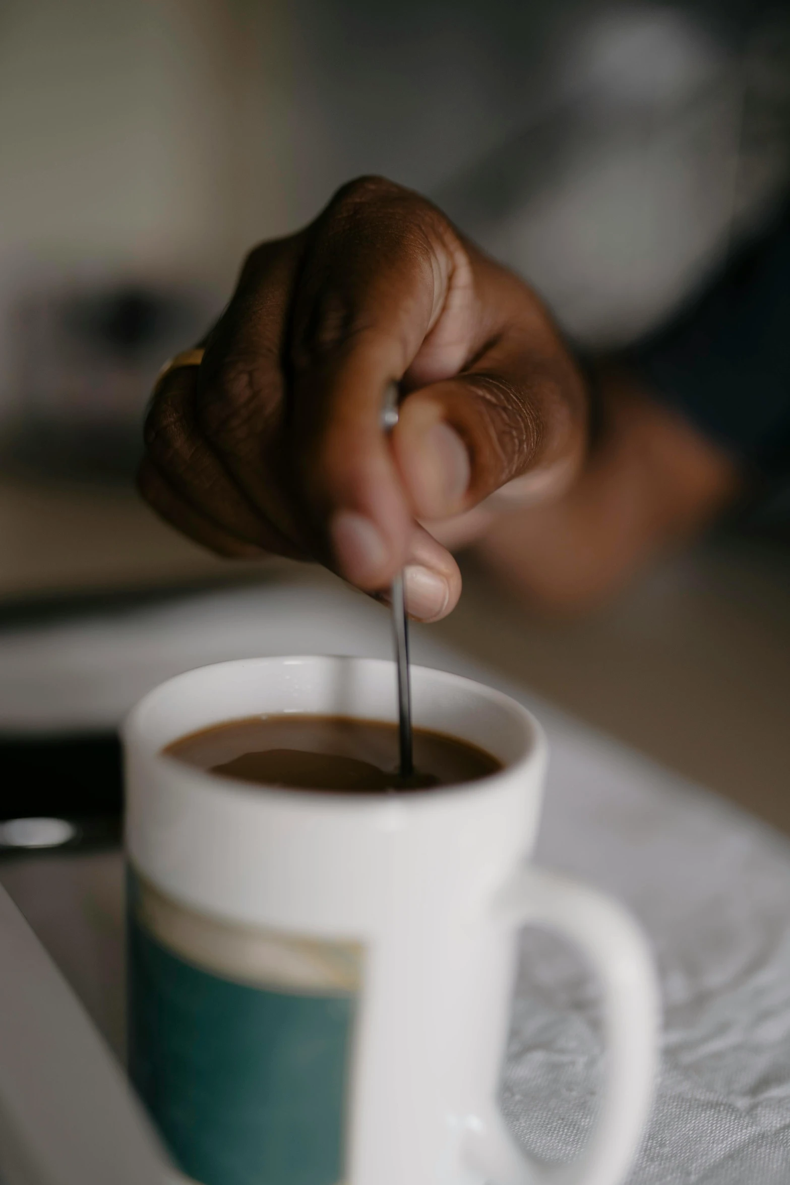 a person getting their spoon in a cup of coffee