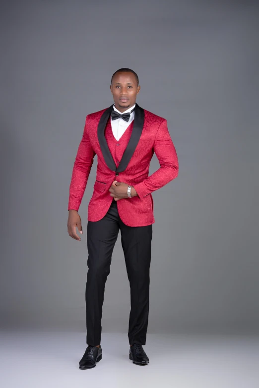 a black man with a red suit and bow tie is standing