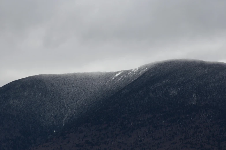 a snow covered mountain under an overcast sky