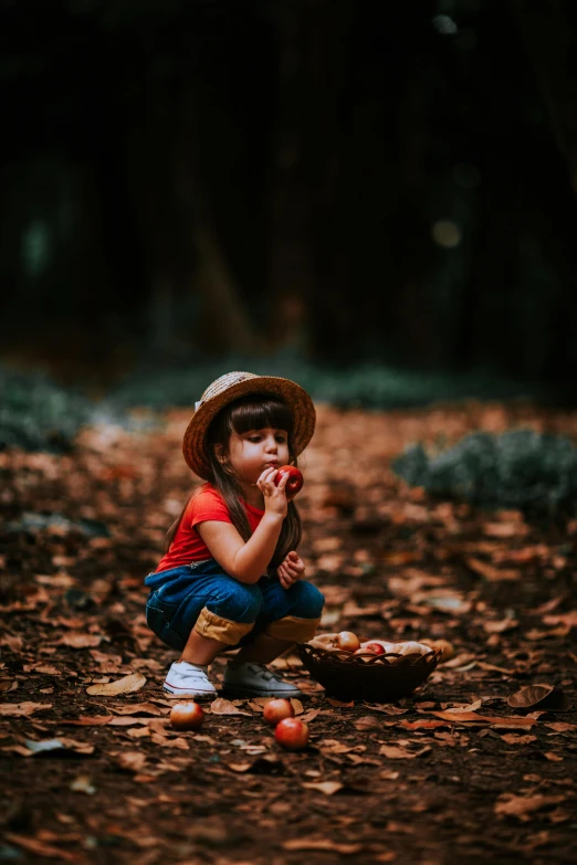  wearing straw hat sitting on ground eating fruit