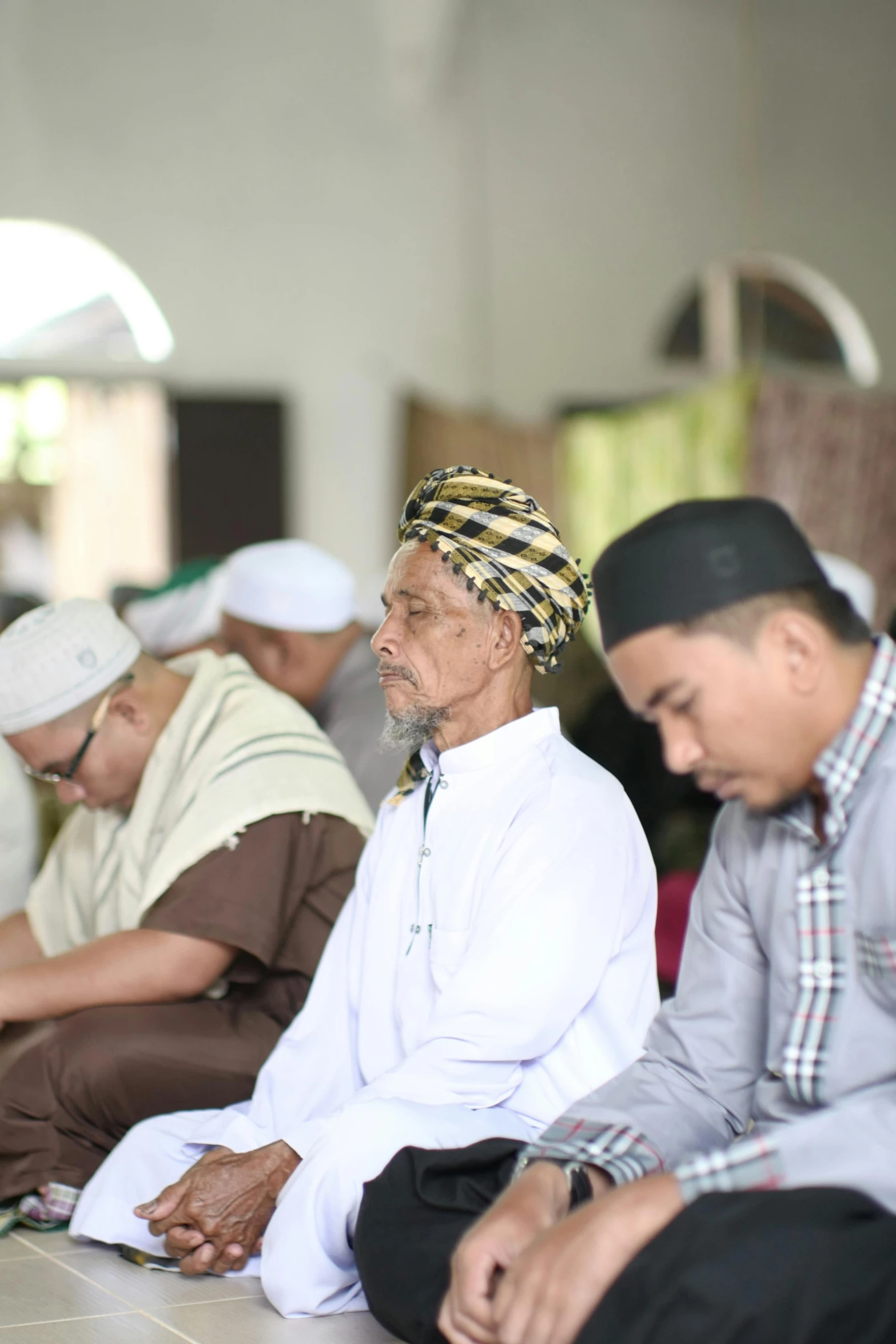 a group of men sitting down on some tile