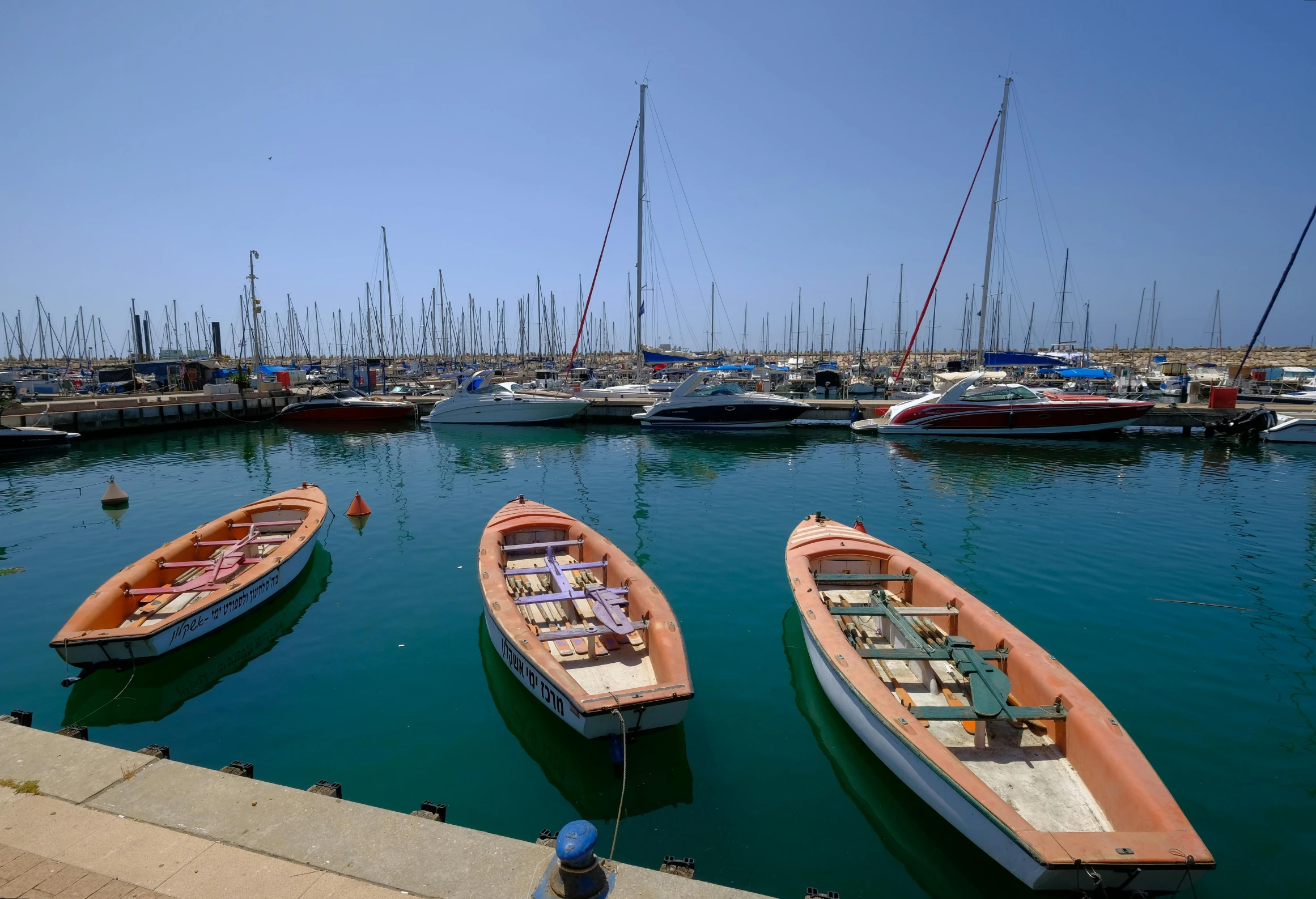 small boats at a harbor filled with sailboats