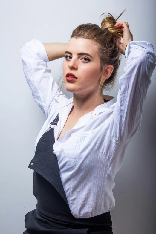 woman with messy hair pulling into top bun