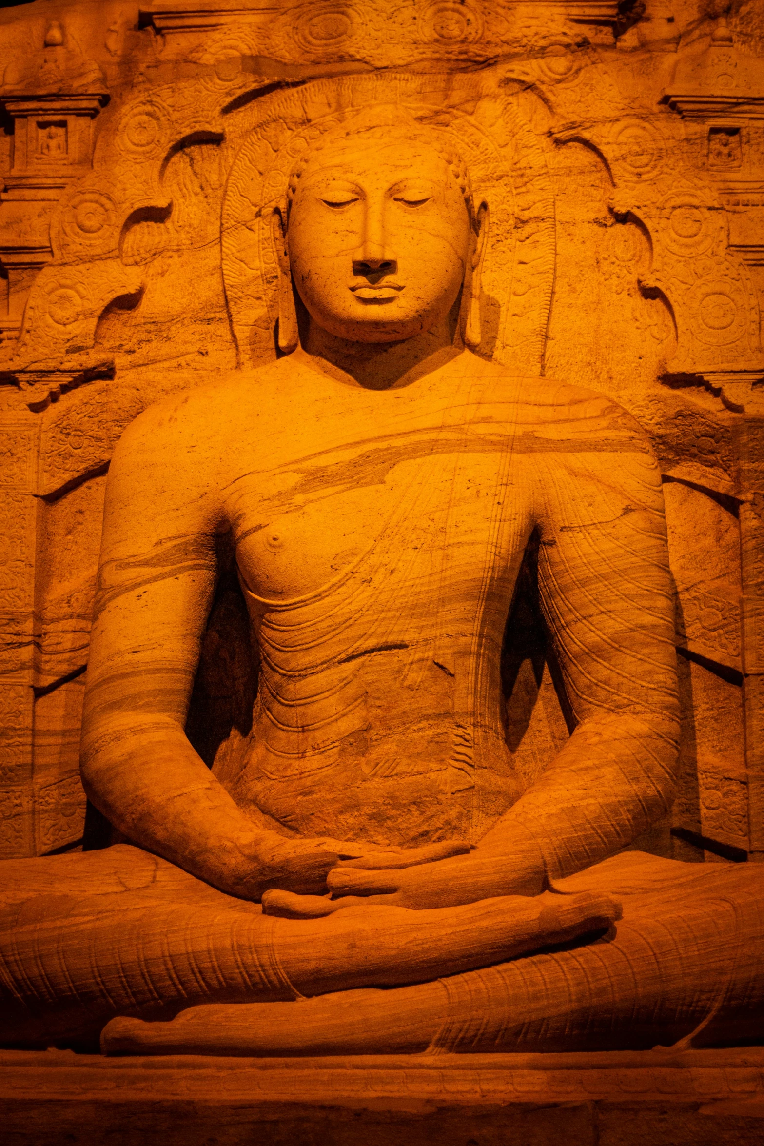 a buddha statue in the center of a large wall