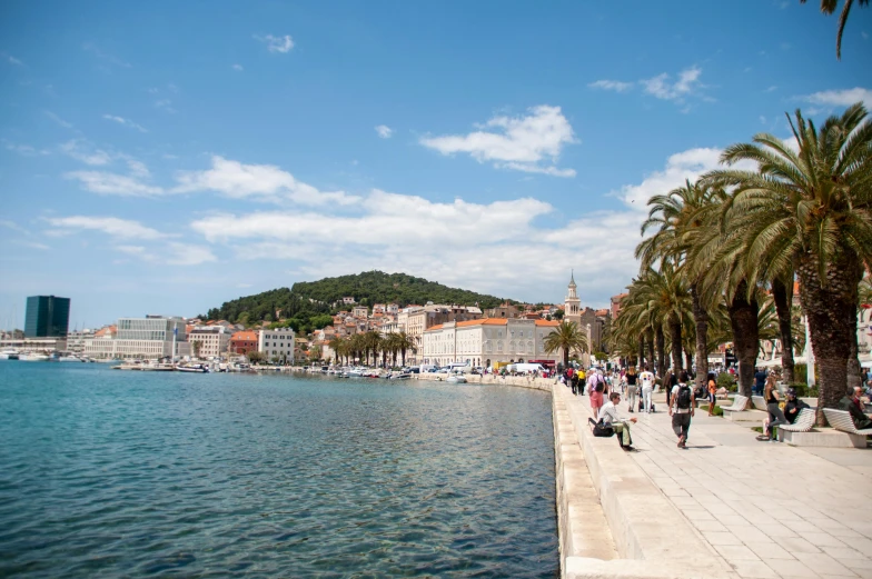 people walk along the beach on a nice day