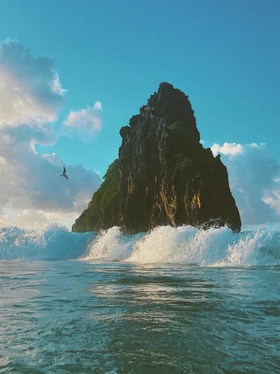 some waves are in the water as one wave floats past a small island