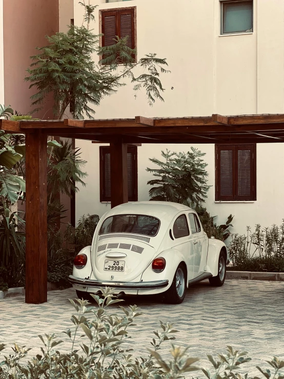 an old fashioned car parked under a wooden cover