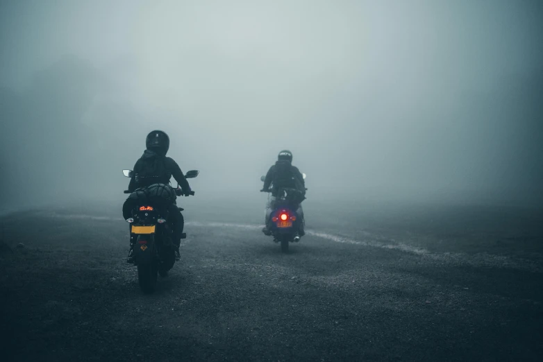 two people are riding motorcycles on a road