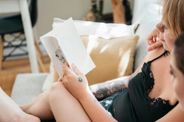 a woman sitting on the couch reading a book