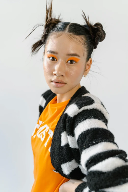 a girl wearing an orange shirt and jacket