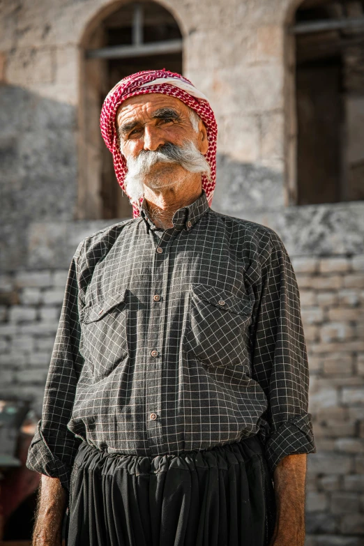 a man wearing a red and black hat in front of a building