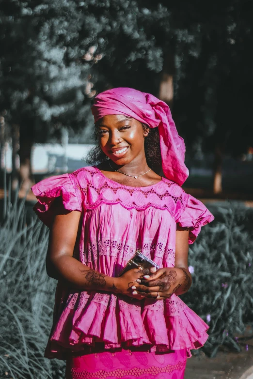 the lady is wearing pink clothing and smiling