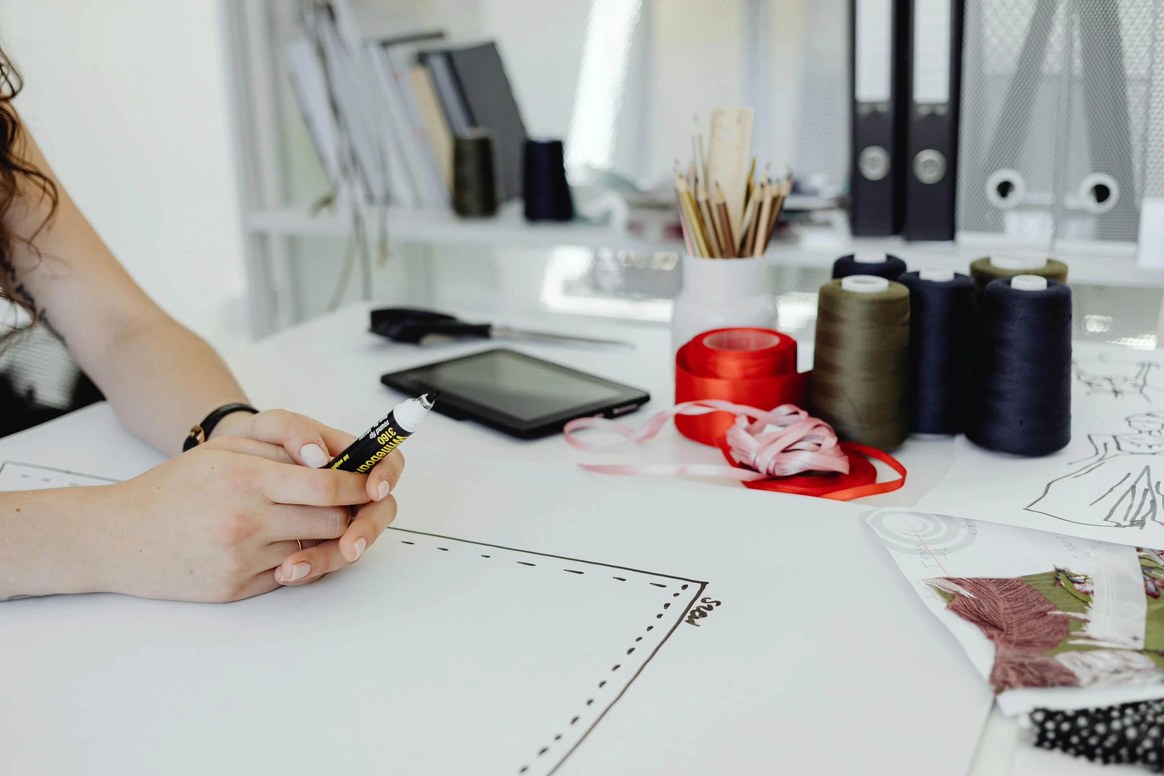 a woman at a table working on sewing and sewing projects