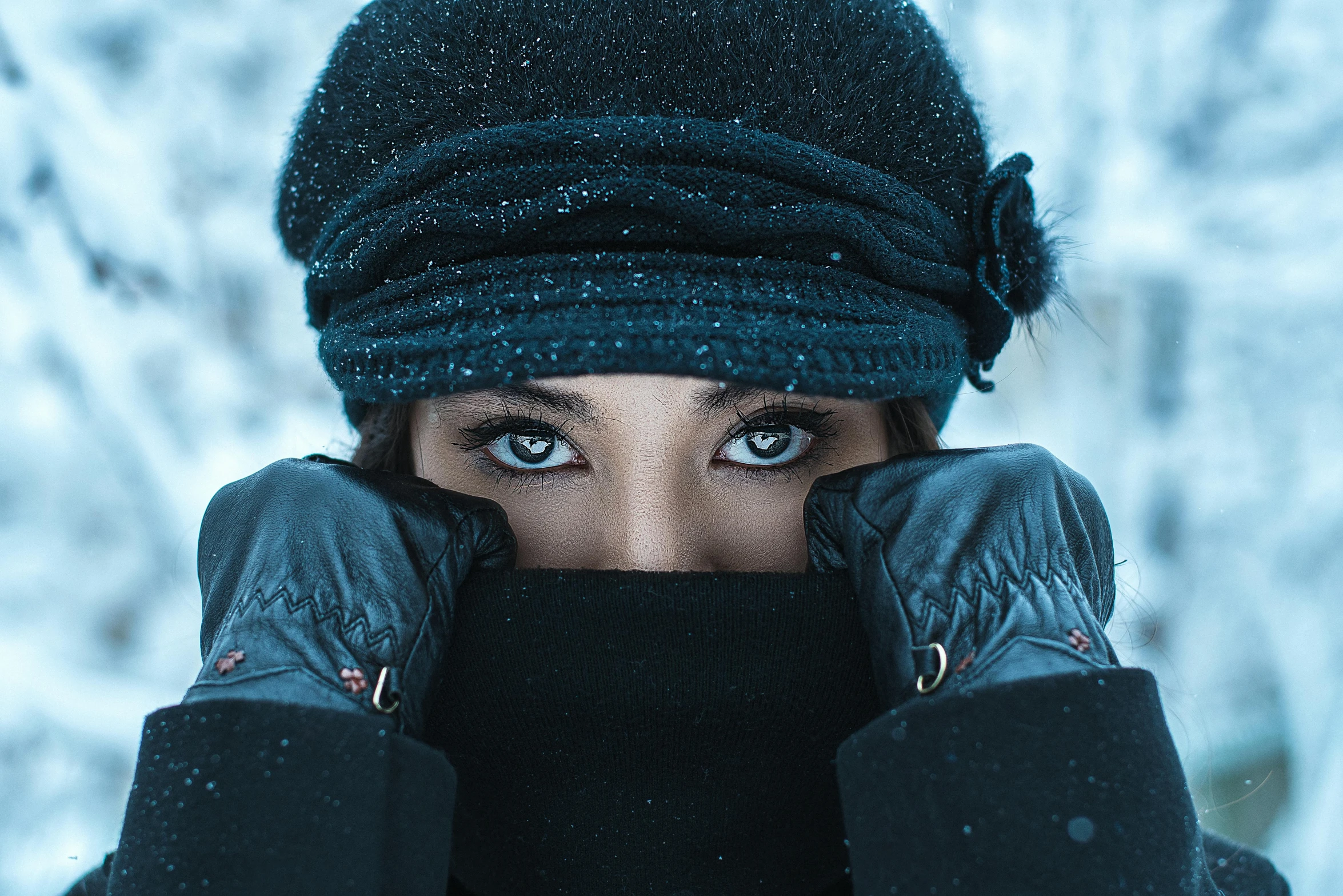 the girl wears gloves and a knitted hat with an unusual expression