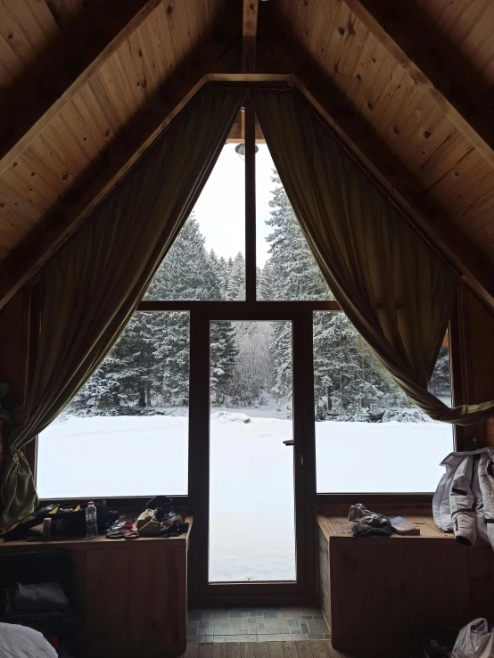 a view from the inside of a loft with a bed and windows