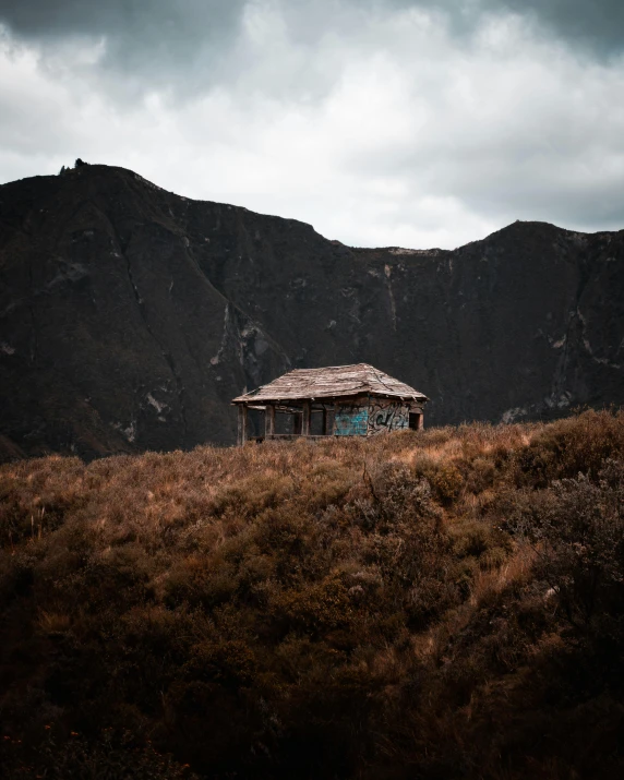 a small house is sitting on a grassy hill