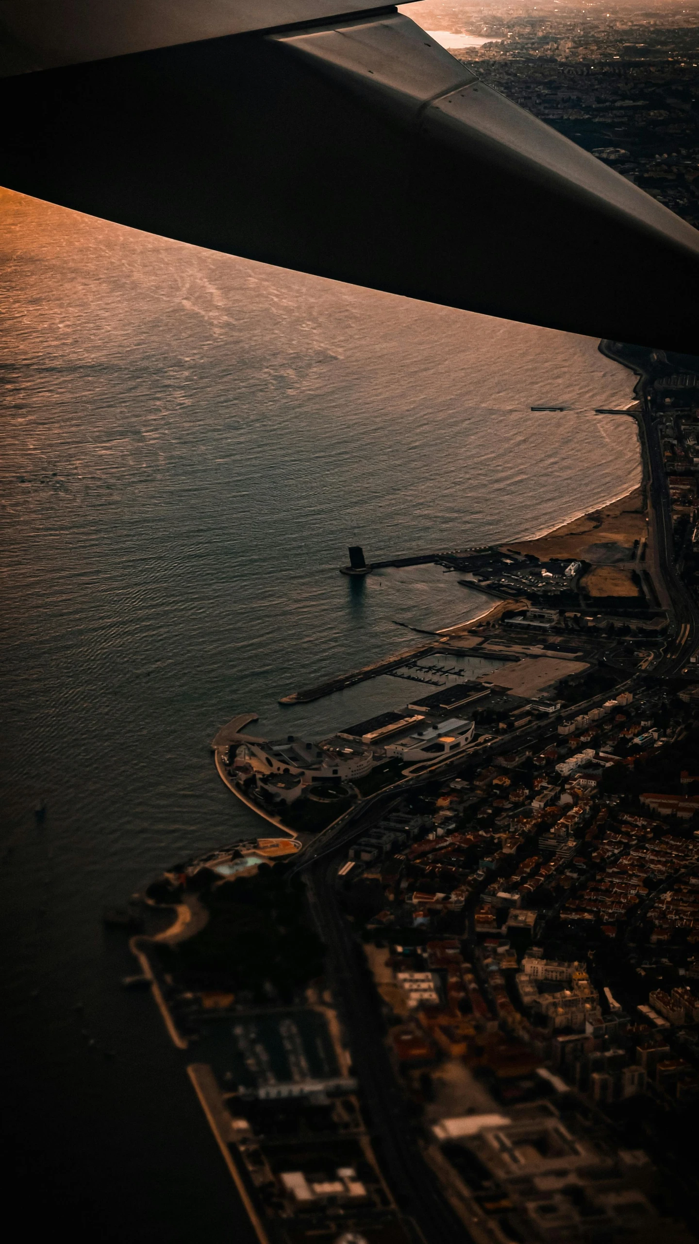 an airplane wing is shown flying above a body of water