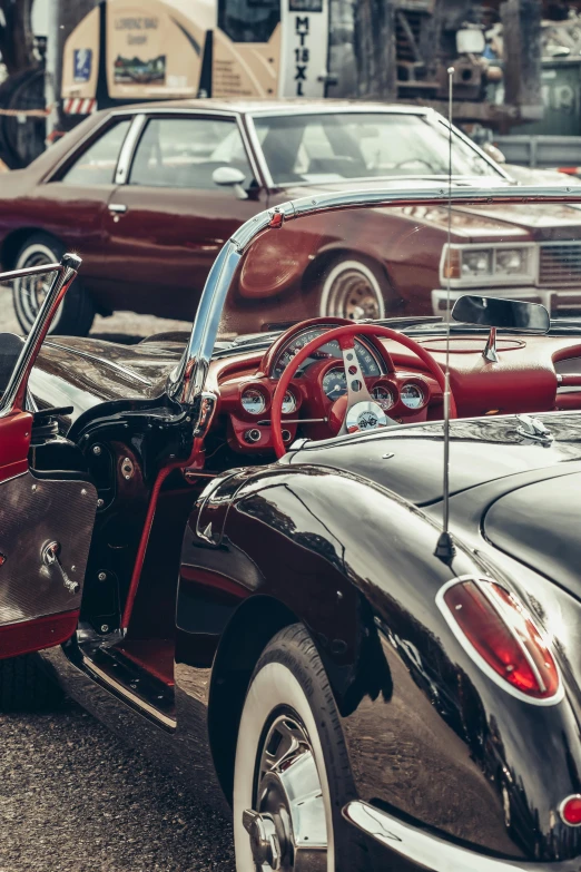 some older cars and one old model car in the street