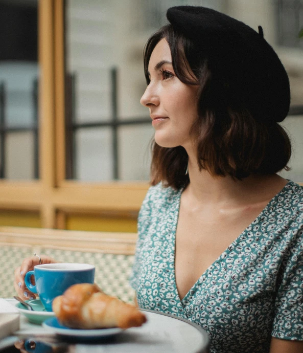 a woman sitting at a table with a coffee cup in her hand