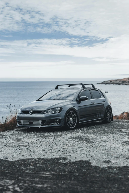 a small gray car sitting on top of a gravel road