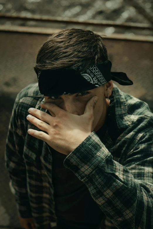 man wearing an ugly black bandana and looking down