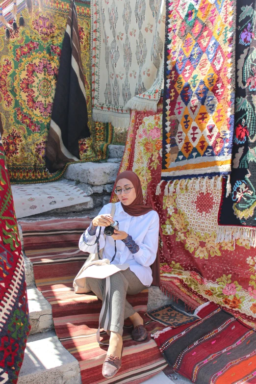 a woman in white sits on some stairs of fabric