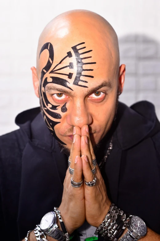 a person with tattoos and rings on his hands