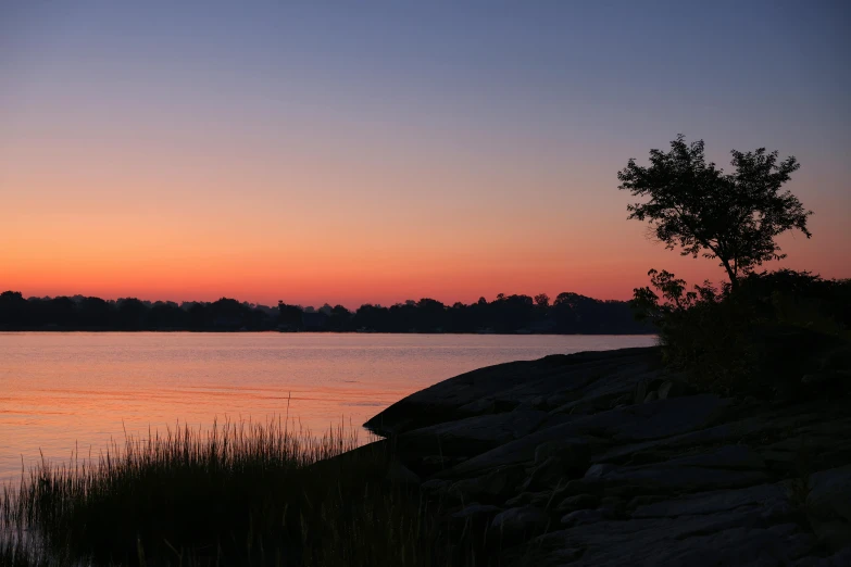 a bright orange and pink sunset reflects the waters