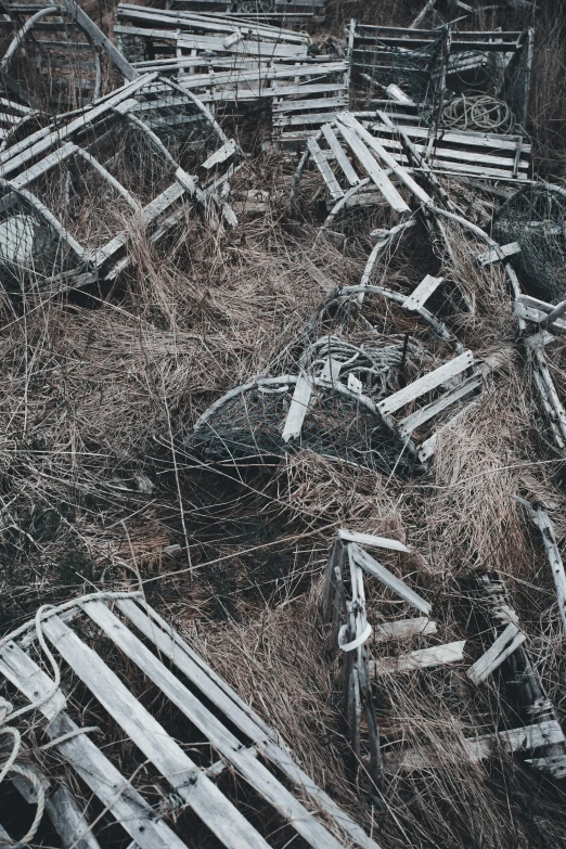 old benches sitting in the grass surrounded by broken wood