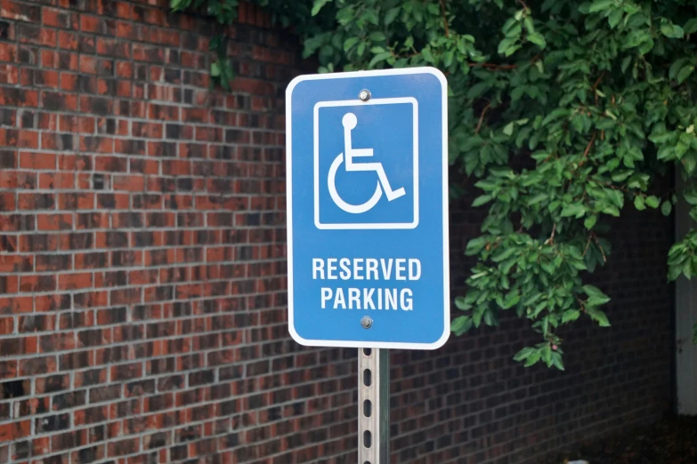 a parking sign is pictured in front of a brick wall