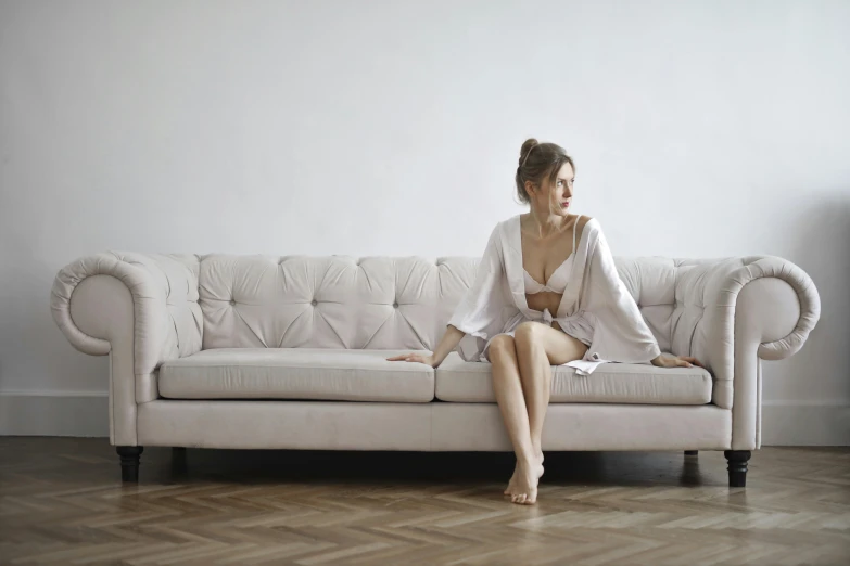 a woman sitting on a couch with her hands on her hips