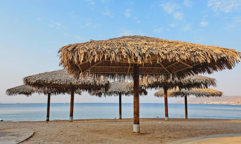 there are two straw umbrellas in the shade