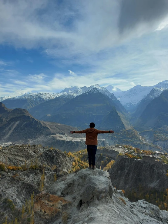 a person on top of a hill with mountains in the background