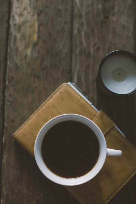 a cup of coffee on a brown mat