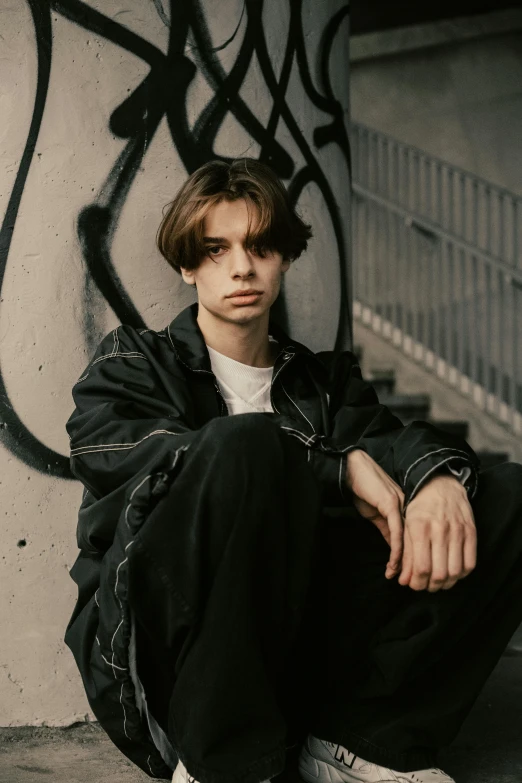 a person sitting on a cement surface next to a wall