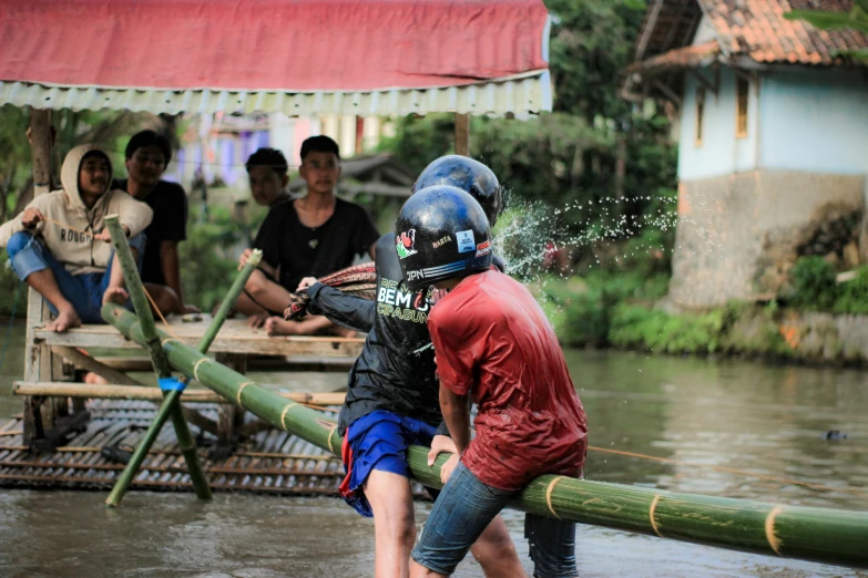 several people in the water holding onto a wooden raft