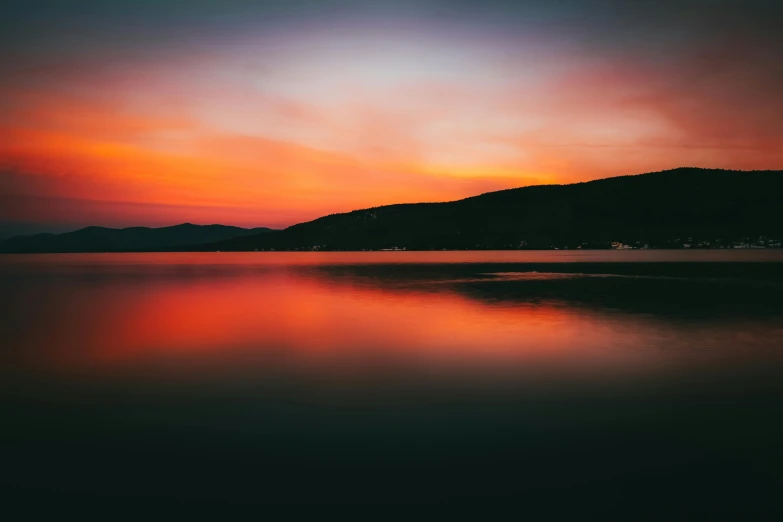 an orange and red sunset reflecting water on the ground