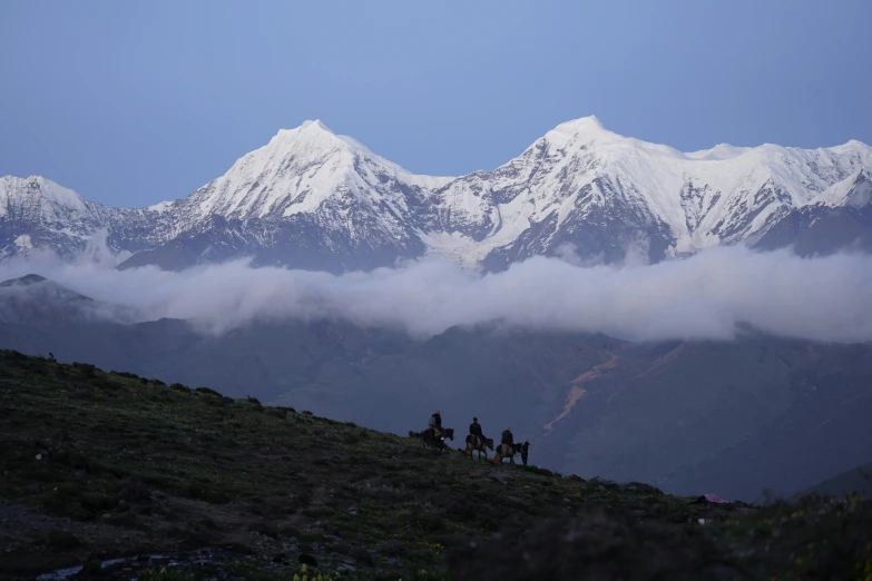 a group of people riding horses up a mountain