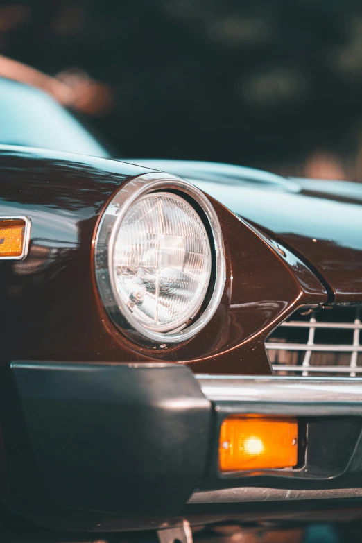 the front end of an old brown car with a headlight