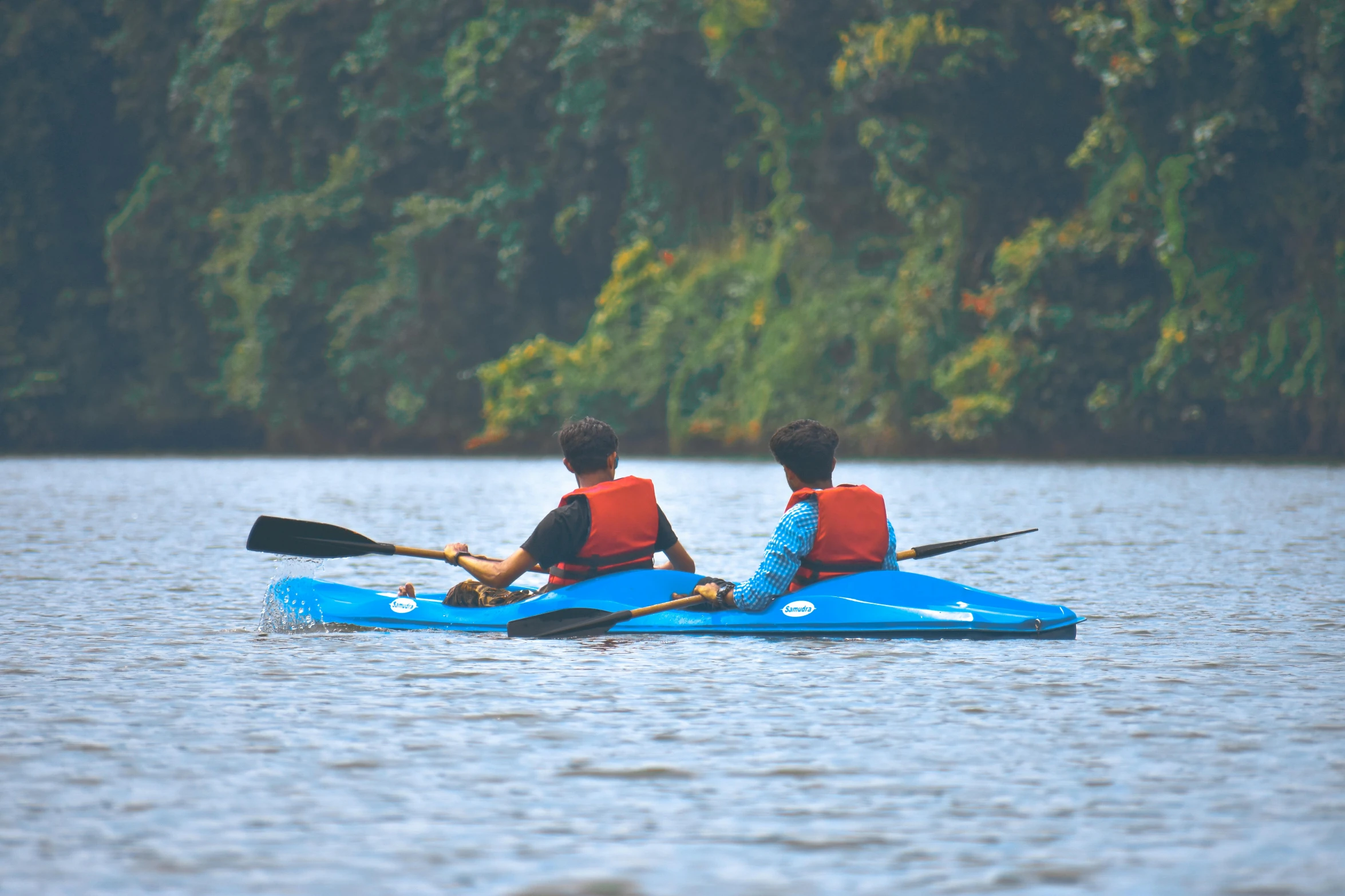 two people on a kayak rowing in the water