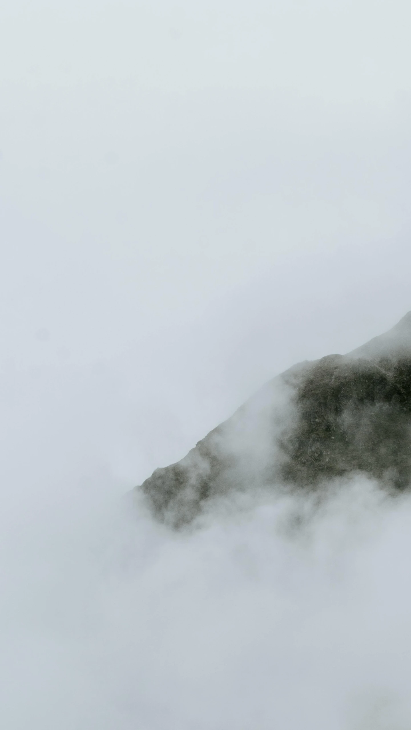 a mountain covered with fog in the day